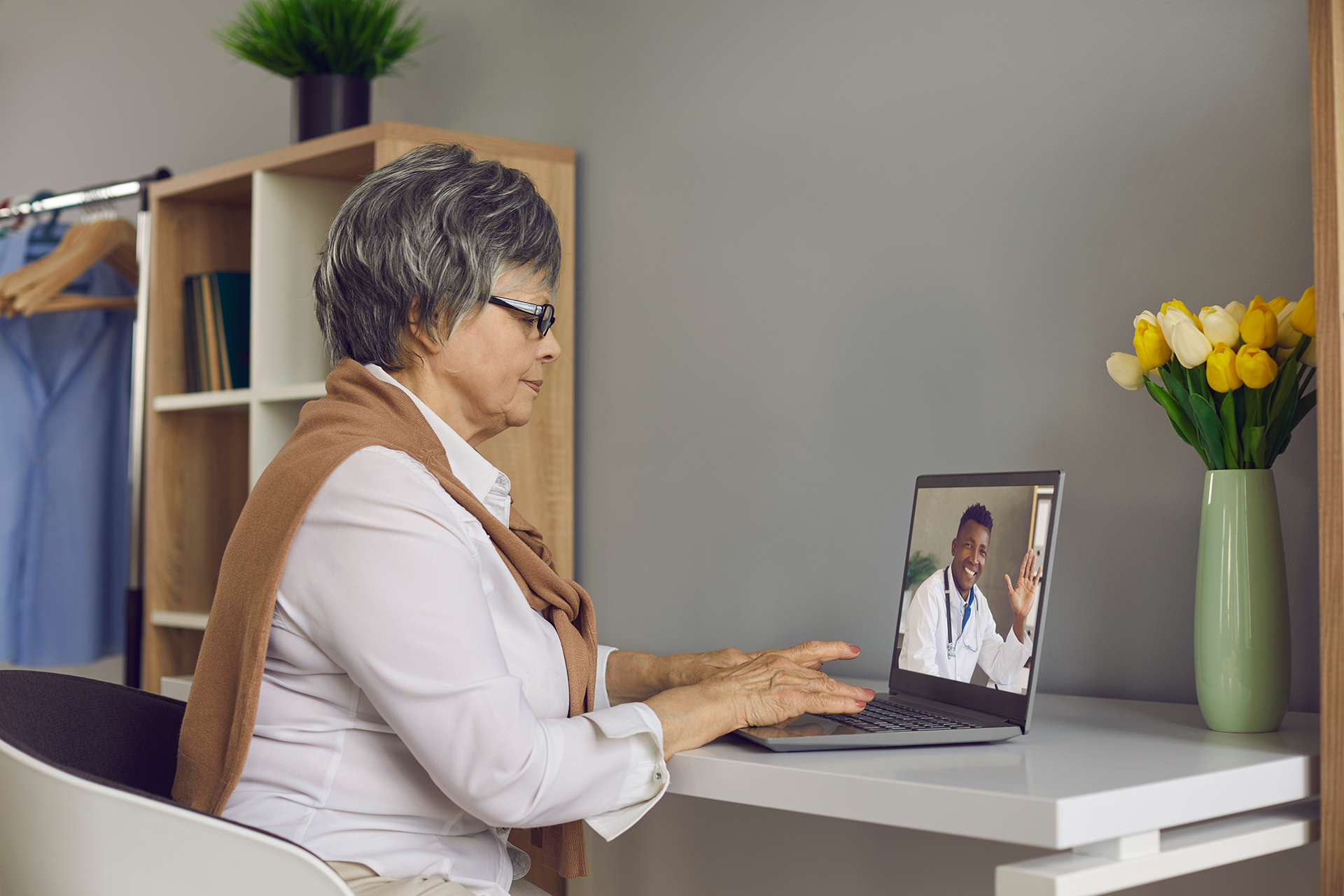 A patient accessing remote healthcare to speak to her doctor from home on her laptop