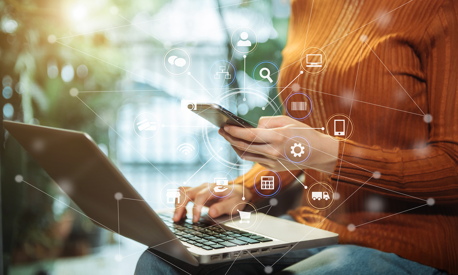 Graphic representing omnichannel connected customer communication. A person is working on a laptop and phone simultaneously